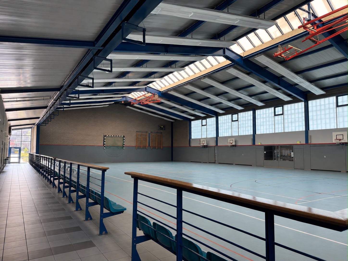 Innenansicht der Sporthalle Jerichow mit Spielfeld, Basketballkörben und Zuschauerbänken